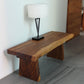 Haussmann Natural Edge solid wood bench in Walnut finish in an entryway with a lamp on top